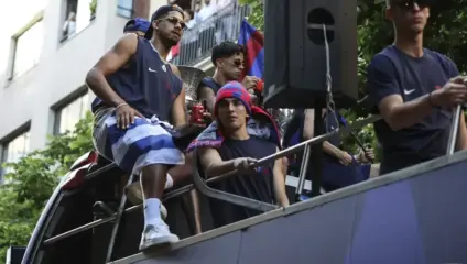 Araujo Liverpool: Ronald Araujo on an open-top bus at a Barcelona title parade, wearing club colours and sunglasses, with teammates/supporters around him